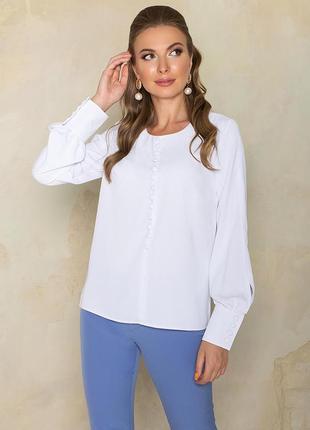 Свободная блуза белого цвета с декоративными пуговицами, имитирующими центральную застежку по центру переда.2 фото
