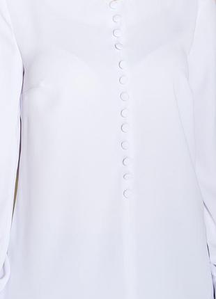 Свободная блуза белого цвета с декоративными пуговицами, имитирующими центральную застежку по центру переда.3 фото