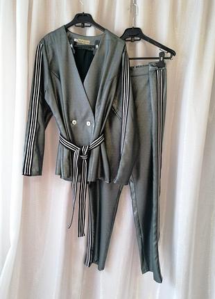 Ефектний брючний костюм з матеріалу з напиленням «металік» складається з піджака з гудзиками і зауж