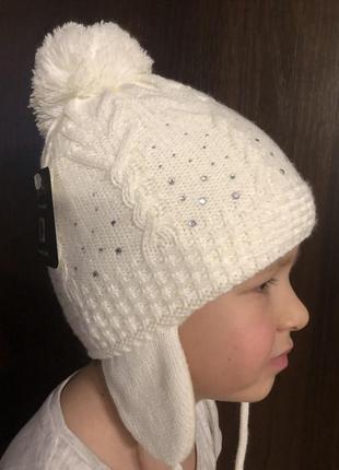 Детская белая шапочка с рисунком бубоном ушками завязками1 фото