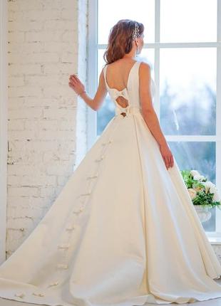 Довга атласна весільна сукня кольору айворі