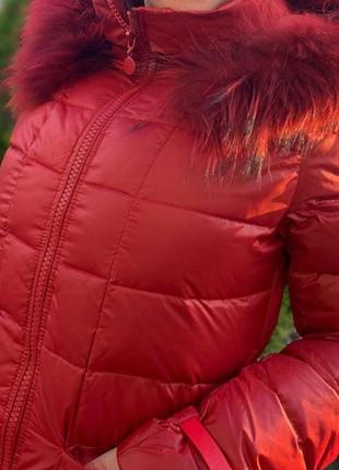 Пуховик женский зимний красного цвета с капюшоном и мехом енота в наличии7 фото