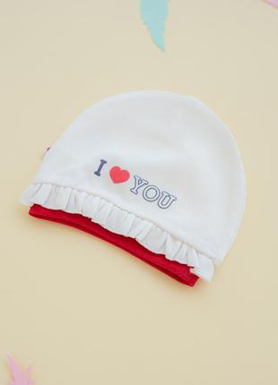 Біла шапочка з рюшами для самих маленьких з колекції «i love mum&dad».