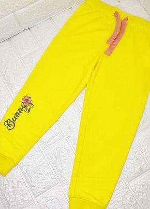Легкие спортивные штаны в желтом цвете.