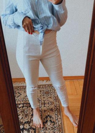 Білі стрейчеві джинси з розрізами на колінах