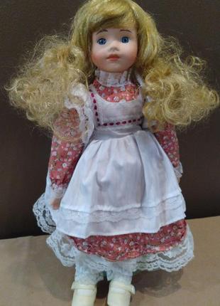 Голубоглазая фарфоровая кукла девочка the classic collection porcelain doll на подставке.
