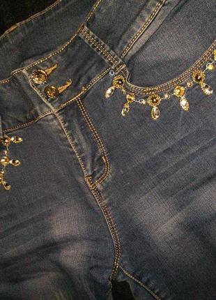 Женские джинсы голубого цвета со стразами на карманах