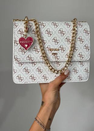 Розкішна біла брендова сумка в стилі guess з ланцюжком і сердечком сумка біла з золотим ланцюжком з червоною підкладкою всередині5 фото