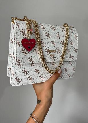 Розкішна біла брендова сумка в стилі guess з ланцюжком і сердечком сумка біла з золотим ланцюжком з червоною підкладкою всередині7 фото