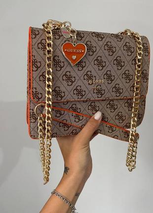 Розкішна бежева помаранчева брендова яскрава сумочка в стилі guess з ланцюжком і сердечком яркая сумка кофейная оранжевая с золотой цепочкой