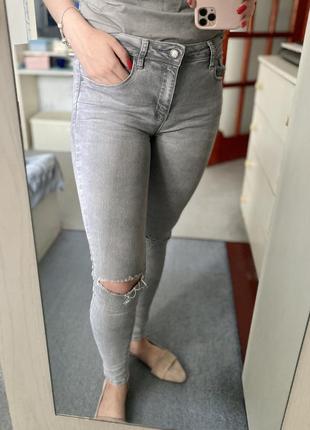 Сірі джинси із порізами на колінах