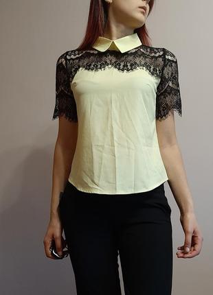 Жовта блузка з чорним мереживом.