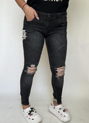 Тёмные джинсы скинни, порванные с цепочками на ноге1 фото
