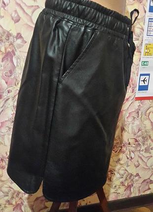 Спідниця з еко-шкіри з косими кишенями