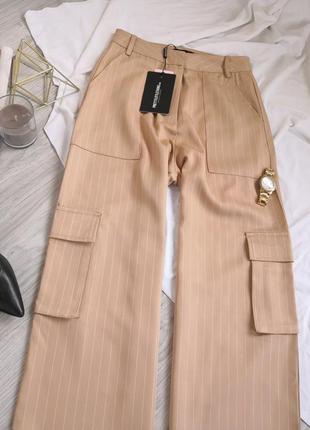 Бежєві брюки в смужку кльош від стегна з розрізами на штанках кармани5 фото