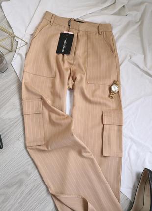 Бежєві брюки в смужку кльош від стегна з розрізами на штанках кармани2 фото
