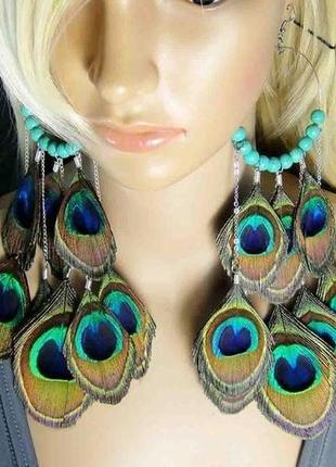 Яскраві довгі сережки з пір'ям павича