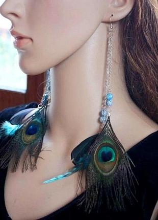 Яскраві довгі сережки з пір'ям павича