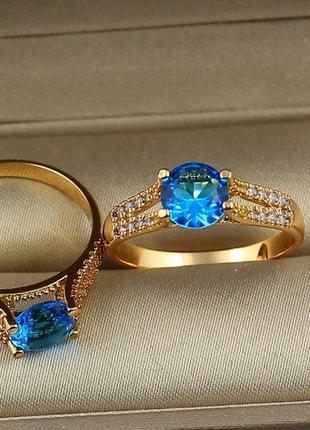 Кольцо xuping jewelry с голубым камнем на ножке из двух дорожек с камешками р 18 золотистое