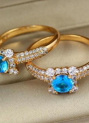 Кольцо xuping jewelry с голубым камнем в квадрате из белых камней р 17 золотистое