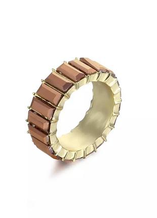Масивне жіноче кільце з яскравими сяючими коричневими камінцями золотистого кольору