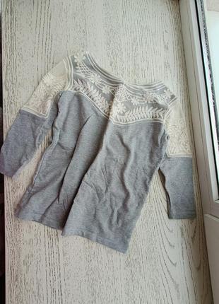 Сіра кофточка з ажурними плечами.