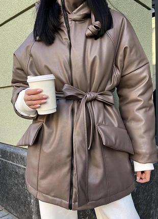 Жіноча зимова куртка мокко з поясом з капішоном тепла шкіряна з кишенями силікон женская зимняя кожаная1 фото