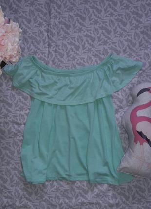 Футболка сперелиной и спушеними плечами.