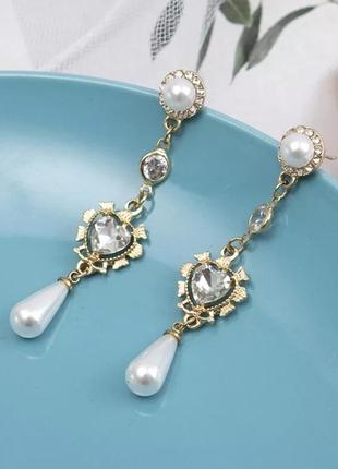 Сережки-підвіски з білим кристалом у формі серця й підвіски штучних перлів