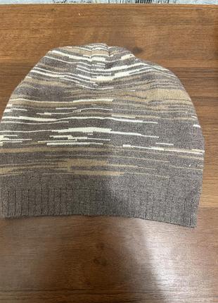 Коричнева з полоскою шапка з  китицями меховими