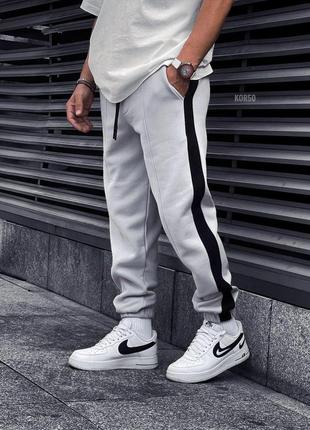 Мужские белые с черной полоской теплые спортивные штаны на флисе с резинками зауженые спортивки1 фото