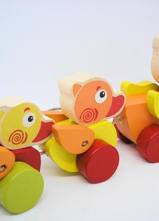 Іграшка дерев'яна дитяча різнокольорова розвиваюча каталка мандруючі каченята на шнурочку cubika3 фото