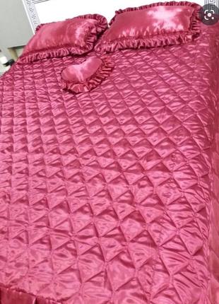 Яркое розовое стеганое покрывало с подушками на кровать