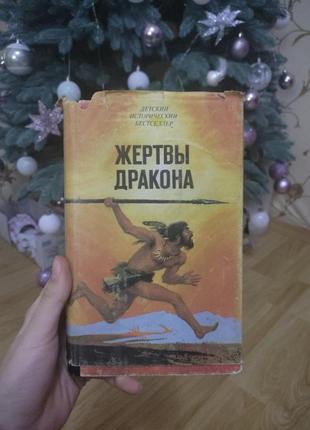 Продаю книгу "жертвы дракона", б/у стан, з недоліками та пожовтілими сторінками, зверху є паперова обкладинка та всередині ілюстрації