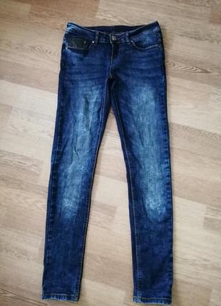 Джинсы с потёртостью зауженые к низу.