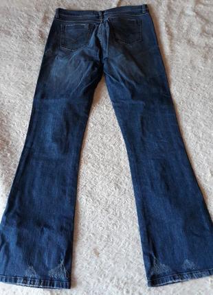 Синие джинсы с рваными коленками2 фото