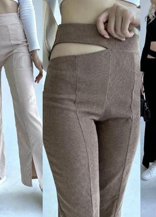 Брюки клеш с разрезами спереди и вырезом сбоку.