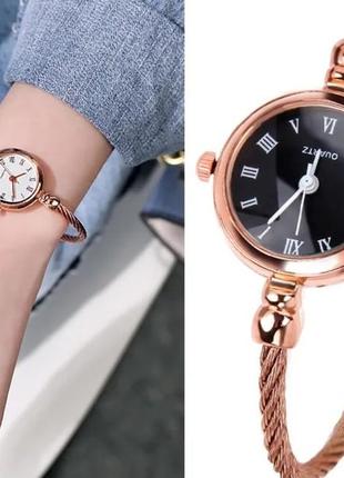Годинник —браслет кольору рожевого золота.