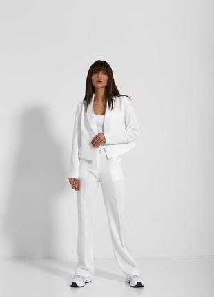 Женский брючный костюм белого цвета: свободные классические брюки и короткий пиджак 42-484 фото