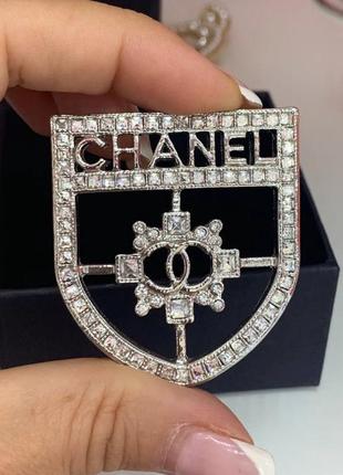 Брошка у формі ордена з логотипом і фірмовим написом