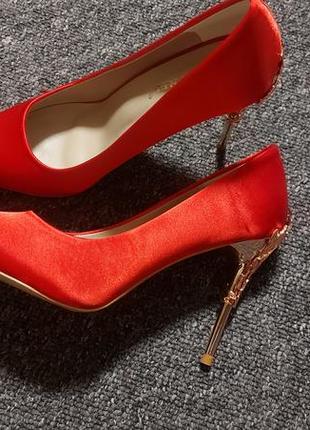 Яскраві червоні туфлі на шпильці з ажурним дизайном
