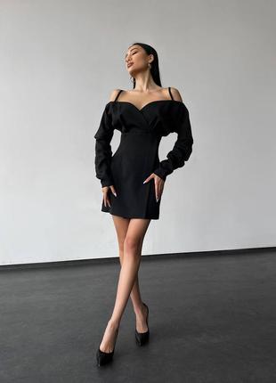 Изысканное черное платье с длинными рукавами и открытыми плечами.