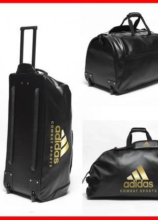 Спортивная дорожная сумка на колесах adidas combat sports с выдвижной ручкой обьем 120 литров из pu-кожи1 фото