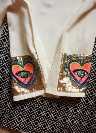 Біла щільна блуза з коротким рукавом кольоровими кишенями з боків золоті з малюнком6 фото