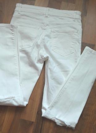 Стильные,белоснежные джинсы с дырками на  коленях.2 фото