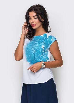 Біла блузка з об'ємною блакитною квіткою на поличці